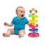 Baby sitting next to a colorful toy with a white background