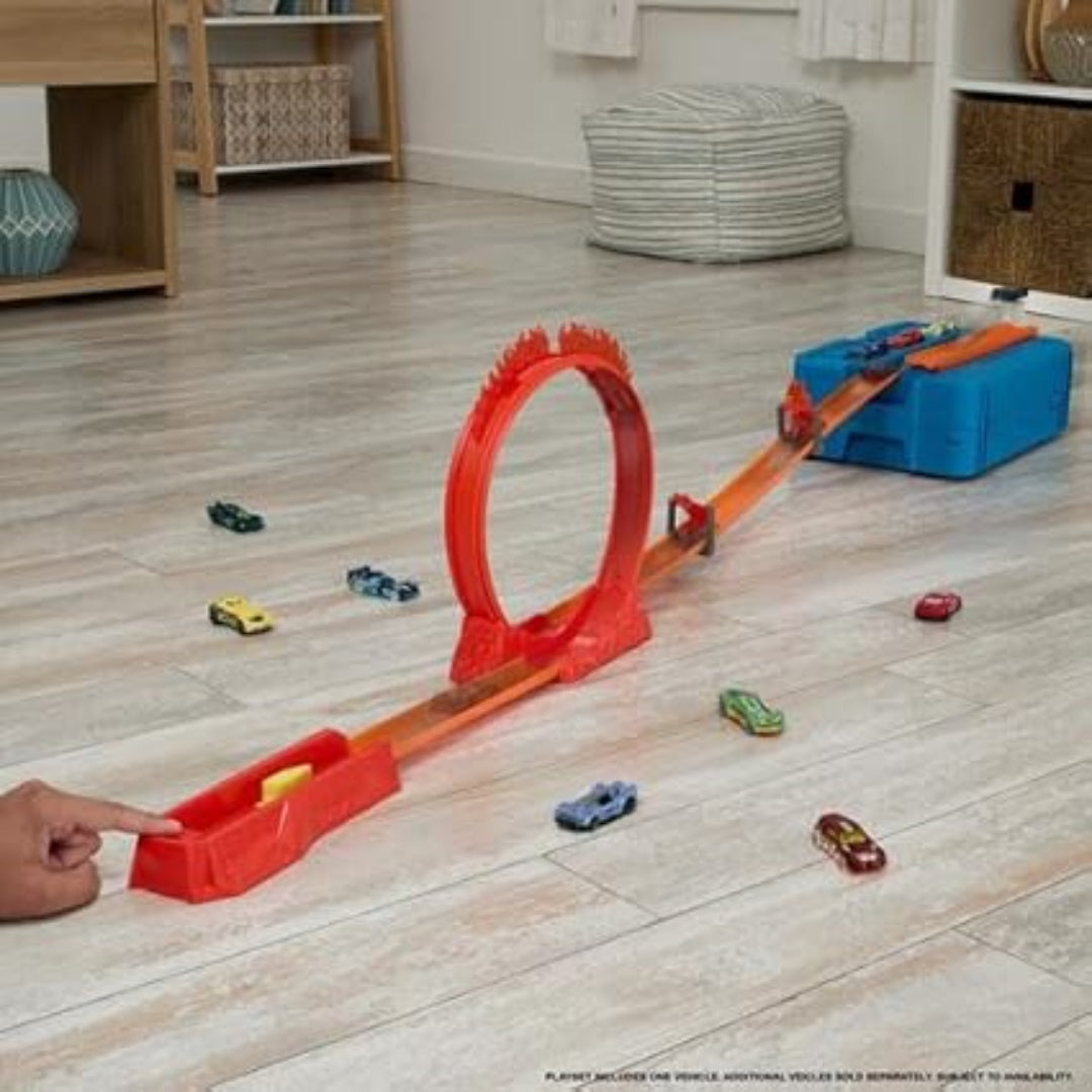 Toy track set with cars on a wooden floor in a room.