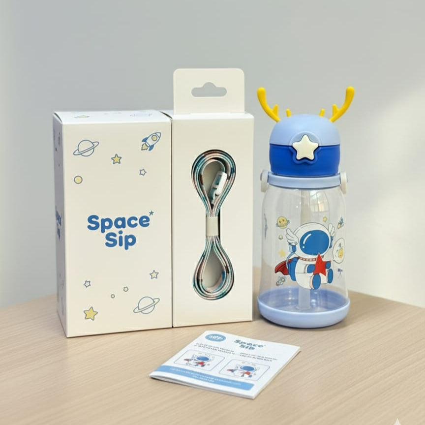 Children's tumbler with deer design, spoon, and packaging on a wooden surface.