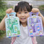 Child holding two toy packaging boxes with cartoon characters outdoors.