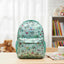 Children's backpack with butterfly pattern on a table with books and a teddy bear.