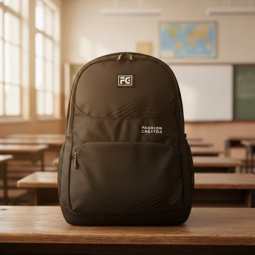 Black backpack with 'Fabric Creations' logo on a desk in a classroom.