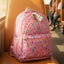 Pink backpack with floral design on a bus seat