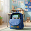 Blue backpack on a rug in a child's room with a desk and toys in the background.