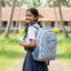 Girl in school uniform with a colorful backpack in a school setting