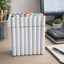 Set of white markers with colorful caps on a desk with office supplies.