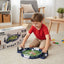 Child playing with a football game set on the floor in a living room.