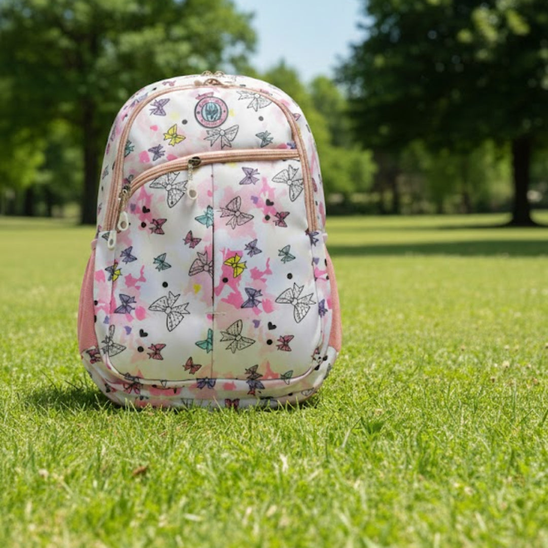Floral-patterned backpack on grass with trees in the background