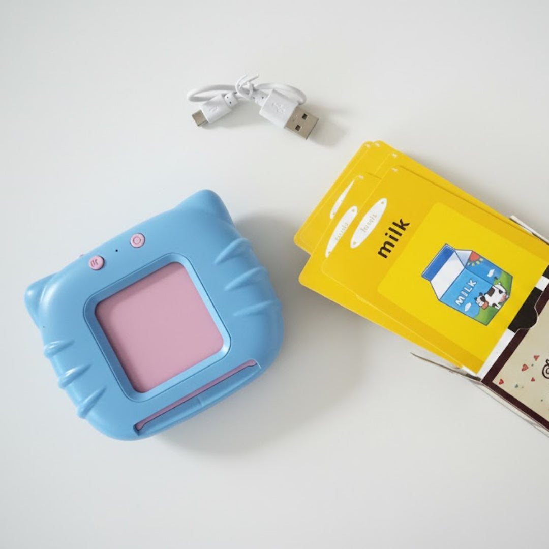 Blue device with pink screen, USB cable, and two boxes on a white background