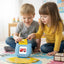 Two children playing with educational toys on a colorful mat in a classroom setting.