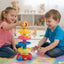Two children playing with a colorful toy stack in a room with toys in the background.