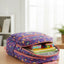 Colorful backpack on a wooden table with books and stationery items inside, in a bright room.