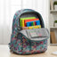 Floral-patterned backpack with colorful books on a wooden table.
