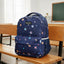Navy blue backpack with colorful patterns on a wooden bench in a classroom setting