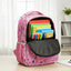 Pink backpack with colorful books on a wooden table