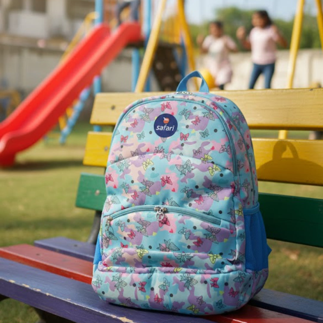 Floral-patterned backpack on a bench with playground in the background